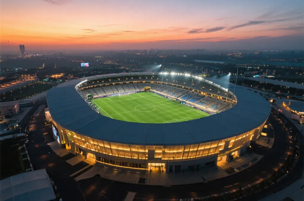 An aerial view of a modern soccer stadium at sunset, glowing lights, lush green pitch, cinematic atmosphere, representing the grand scale of 2026 World Cup